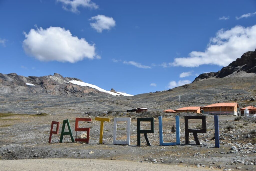 Letras de colores con el nombre “Nevado Pastoruri” situadas en la zona de inicio del recorrido, en la Cordillera Blanca, Perú